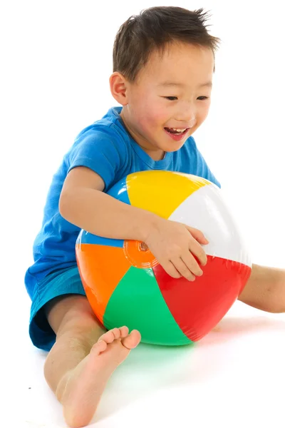 Китайский мальчик играет с пляжным мячом — стоковое фото