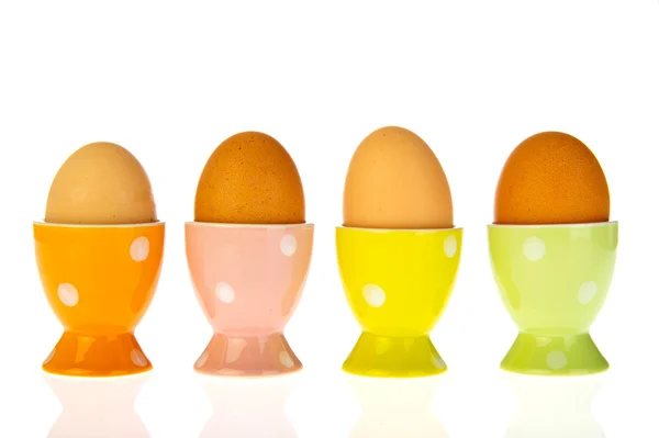 Яйца в цветных чашках — стоковое фото