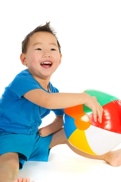 Китайский мальчик с легким гандикапом играет с пляжным мячом — стоковое фото