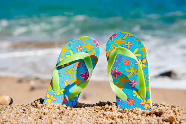 Staande flip flops op het strand — Stockfoto