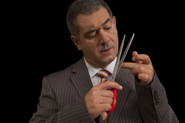 Businessman wearing suit cutting nails with huge scisors Humour — Stock Photo, Image