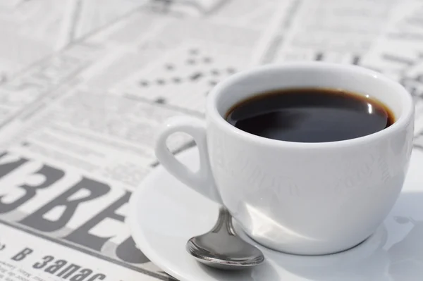 Tasse Kaffee auf russischem Zeitungshintergrund — Stockfoto