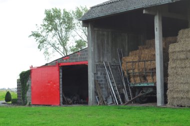 Hay-barn with haycart filled with stacks of hay clipart