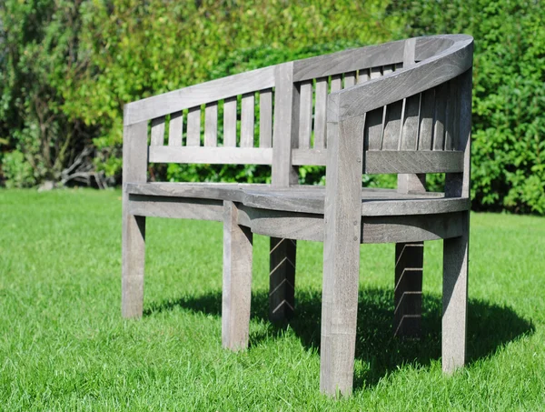Садовая скамейка в траве — стоковое фото