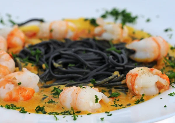 Scampi with inkfish pasta and curry sauce — Stock Photo, Image