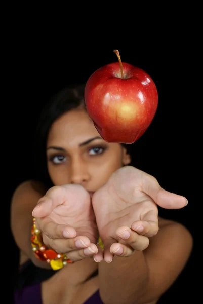 Молодая женщина ловит яблоко — стоковое фото