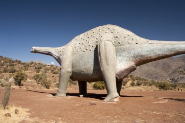 Dinosaur walking in a wild desert clipart