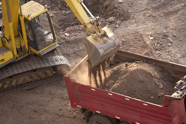 挖掘机装载在一个建筑工地上的一辆卡车 — 图库照片