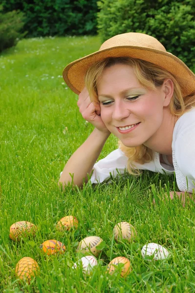 Молода жінка і великодні яйця на траві - Великдень — стокове фото