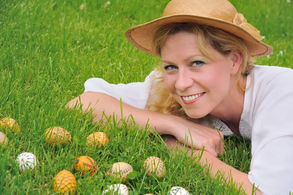 Mujer joven y huevos de Pascua en la hierba - Tiempo de Pascua —  Fotos de Stock