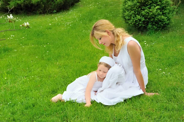 Jovem mãe e filha descansando no prado — Fotografia de Stock