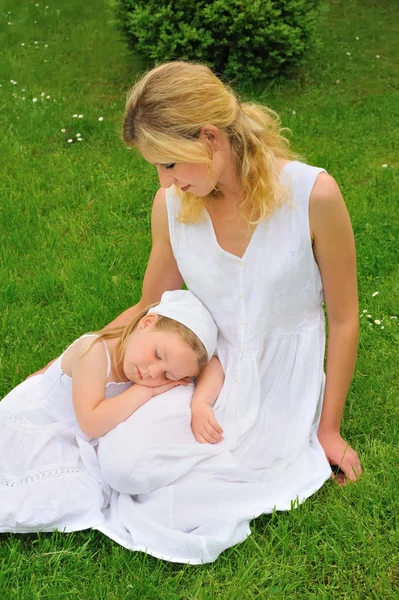 Young mother and daughter resting in meadow — Stock Photo, Image