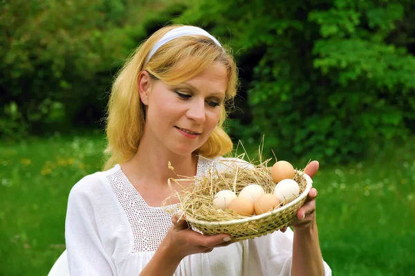 Felice giovane donna che tiene uova fresche — Foto Stock