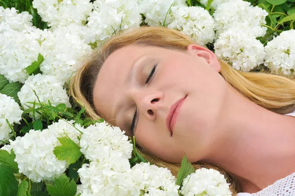 Молода жінка, що лежить у квітах - сніжки — стокове фото