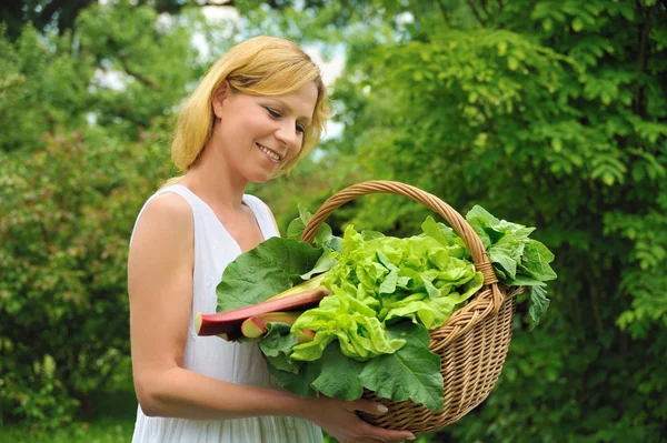 Νέα γυναίκα που κρατά το καλάθι με λαχανικά — Φωτογραφία Αρχείου