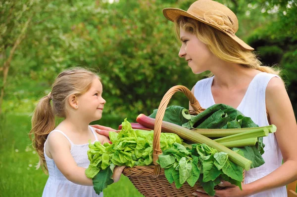 Ung kvinna och dotter med färska grönsaker — Stockfoto