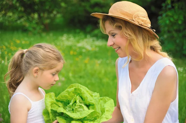 Mladá matka a dcera s hlávkovým salátem — Stock fotografie