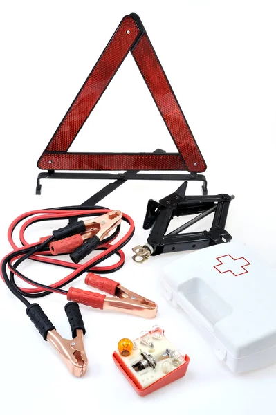 Emergency kit for car - first aid kit, car jack, jumper cables, warning tri — Stock Photo, Image