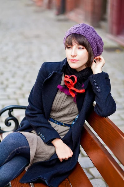 Young woman sitting on a bench — Stock Photo, Image