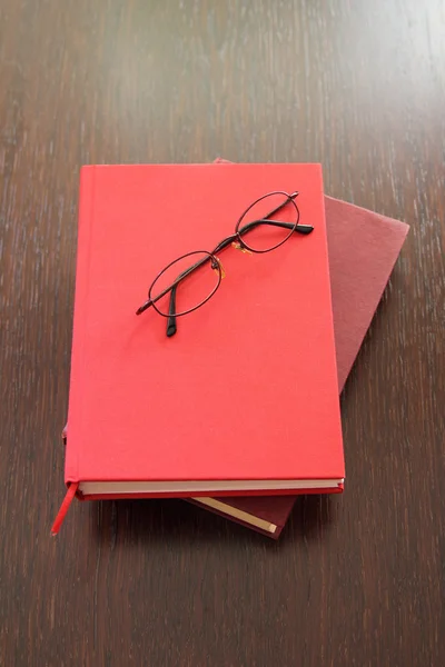Gözlük ve iki kırmızı kitap — Stok fotoğraf