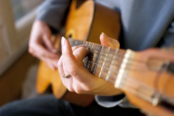 Καφέ κιθάρα στα χέρια του ο τύπος που παίζει — Φωτογραφία Αρχείου