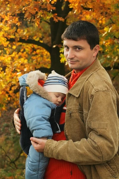 Father holding his son in baby carrier — Stock Photo, Image