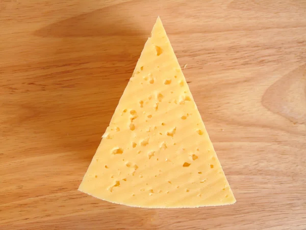 Шматочок сиру на обробній дошці. Ізоляція — стокове фото