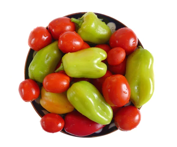 Čerstvá rajčata a papriky na talíři — Stock fotografie