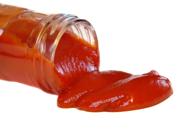 Sabroso ketchup que sale de la botella aislado sobre fondo blanco — Foto de Stock