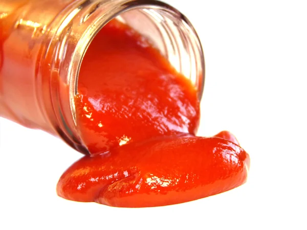 Вкусный кетчуп, вытекающий из бутылки на белом фоне — стоковое фото