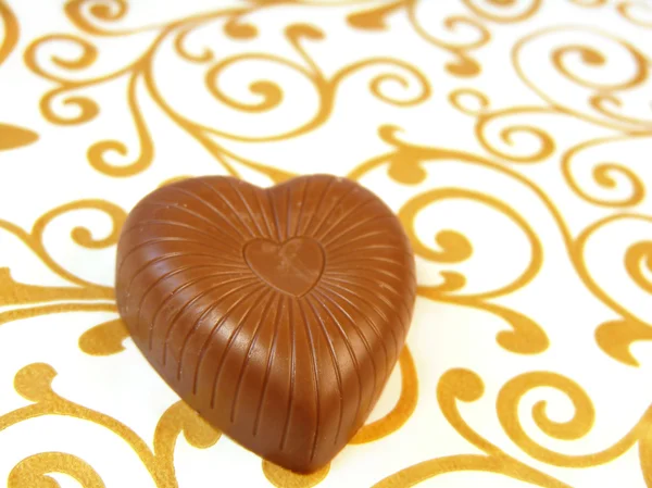 Chocolates deliciosos en forma de corazón sobre un fondo de color — Foto de Stock