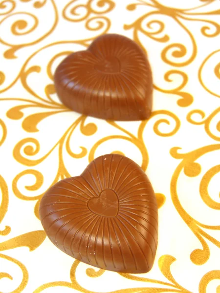 Chocolates Mouthwatering em forma de coração em um fundo colorido — Fotografia de Stock