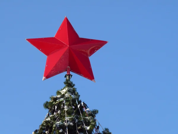 Rudá hvězda na vrcholu stromu. Vánoční dekorace — Stock fotografie