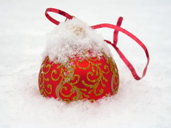 Червоний різдвяний м'яч лежить на снігу — стокове фото