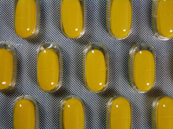 Yellow pills in blister background — Stock Photo, Image