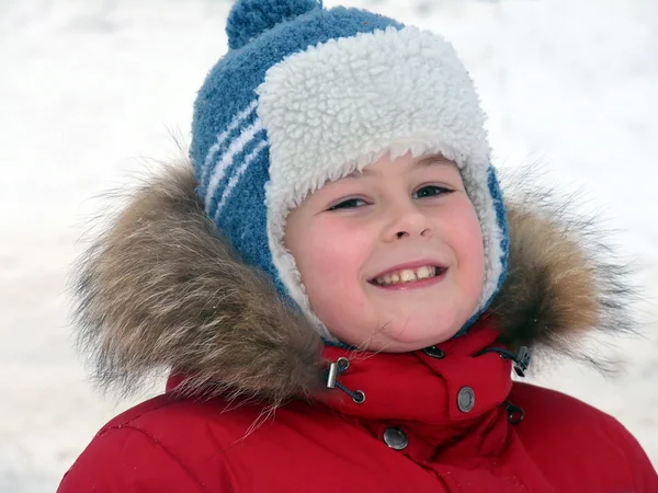 Προσωπογραφία αγοριού στο χειμερινό ιματισμό ενάντια στο σκηνικό του χιονιού — Φωτογραφία Αρχείου