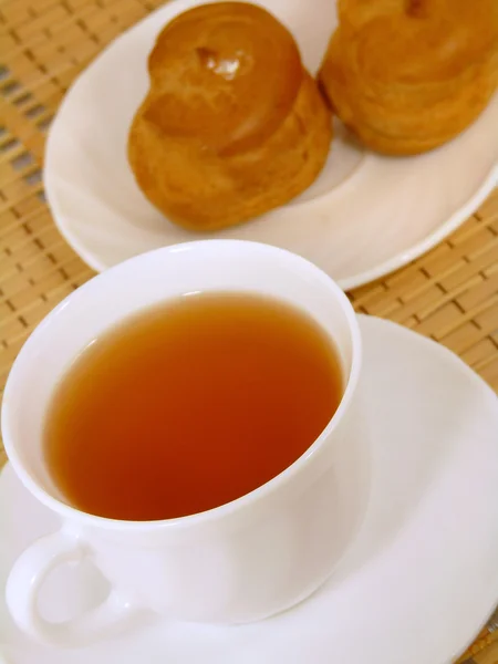 Brassage délicieux gâteau avec de la crème et une tasse de thé — Photo