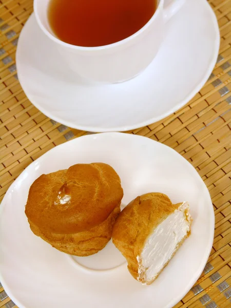 Пивоварение вкусный торт со сливками и чашкой чая — стоковое фото