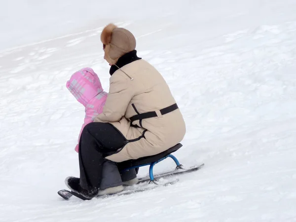Mãe e filha montam uma montanha russa snegokate — Fotografia de Stock