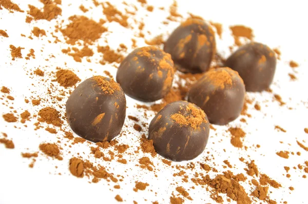 Chocolates polvilhados com cacau, isolados sobre um fundo branco — Fotografia de Stock