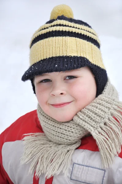 Porträtt av en pojke som sitter i snön — Stockfoto