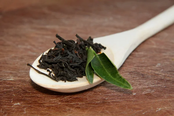Svart te på en trä textur — Stockfoto