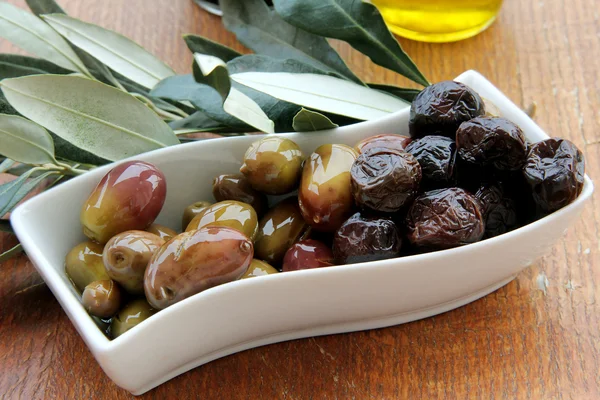 橄榄和橄榄油放在木制桌子上 — 图库照片