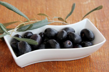 Tahta bir masada zeytin ve zeytin yağı.