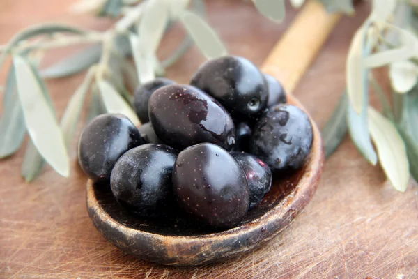 橄榄和橄榄油放在木制桌子上 — 图库照片