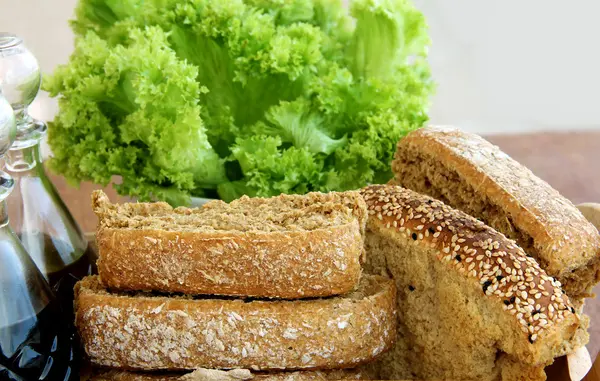 Stilleben med rusk, bröd, smör sallad på trä bakgrund — Stockfoto