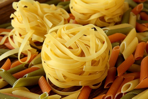 Pasta cruda su fondo legno — Foto Stock