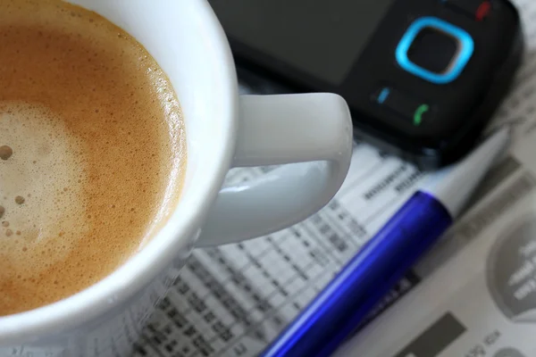 Šálek kávy na pozadí novin s telefonem a pero — Stock fotografie