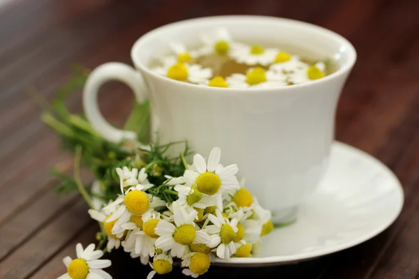 Herbal tea with camomile on a wooden table — Stock Photo, Image