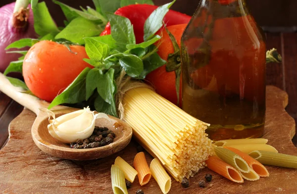 Komposition mit rohen Nudeln, Gemüse, Olivenöl und Kräutern — Stockfoto